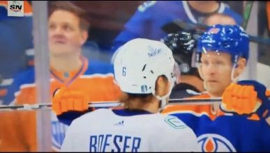 Corey Perry stopping Brock Boeser from joining a scrum between the Vancouver Canucks and Edmonton Oilers.