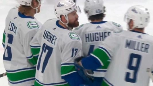 Vancouver Canucks players Brock Boeser, Filip Hronek, Quinn Hughes, and JT Miller