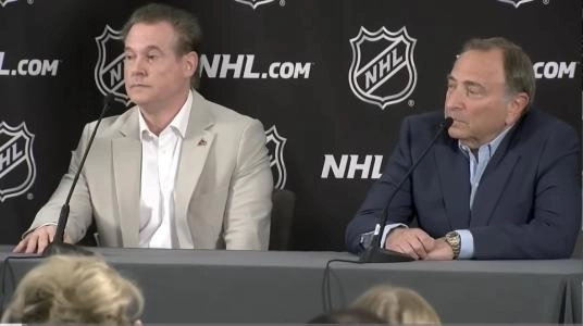 Arizona Coyotes owner Alex Meruelo and NHL commissioner Gary Bettman speaking during a press conference.