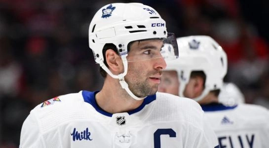 Toronto Maple Leafs captain John Tavares lining up for a faceoff during a road game in the 2023-24 NHL season.