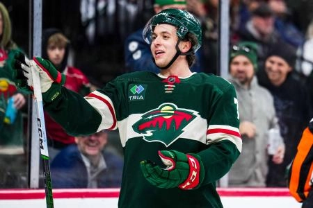 Minnesota Wild defenseman Brock Faber celebrating a goal scored during a home game in the NHL.