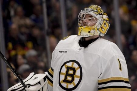 Boston Bruins goaltender Jeremy Swayman looking up into the stands during a break in play during an away game in the NHL.