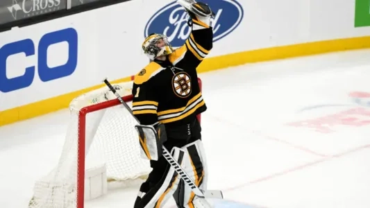 Jeremy Swayman of the Boston Bruins lifts his glove up in the air