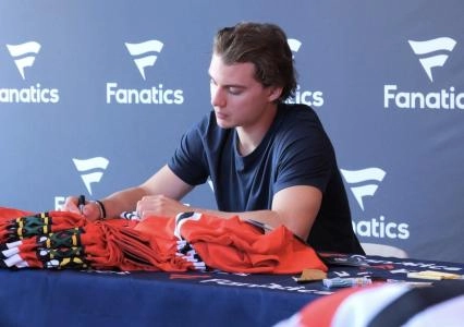 Connor Bedard of the Chicago Blackhawks autographing some Fanatics jerseys