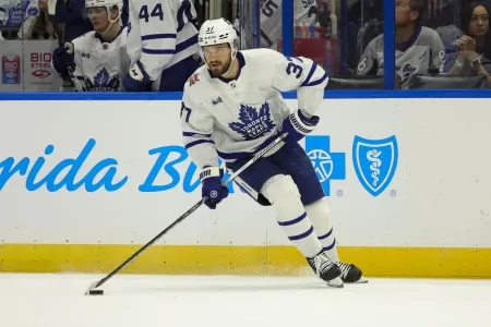 Toronto Maple Leafs defenseman Timothy Liljegren handling a puck in his own zone during an away game in the NHL.
