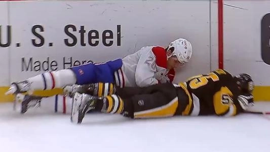 Noel Acciari of the Pittsburgh Penguins lays on the ice next to Juraj Slafkovsky of the Montreal Canadiens
