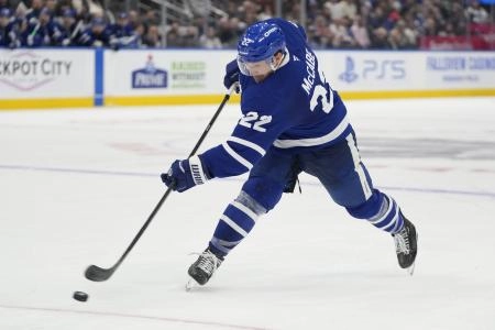 Oct 24, 2024; Toronto, Ontario, CAN; Toronto Maple Leafs defenseman Jake McCabe (22) shoots the puck against the St. Louis Blues during the third period at Scotiabank Arena. Mandatory Credit: John E. Sokolowski-Imagn Images