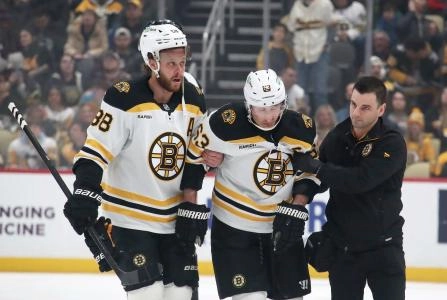 Mar 1, 2025; Pittsburgh, Pennsylvania, USA; Boston Bruins left wing Brad Marchand (63) is helped from the ice by right wing David Pastrnak (88) and a team trainer after suffering an apparent injury against the Pittsburgh Penguins during the first period at PPG Paints Arena. Mandatory Credit: Charles LeClaire-Imagn Images
