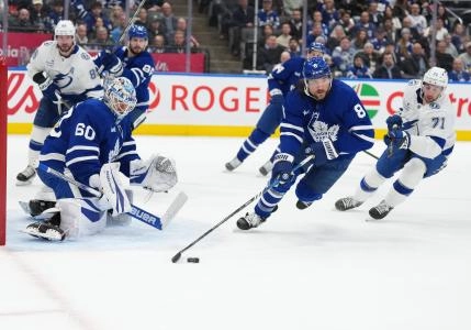 Jan 20, 2025; Toronto, Ontario, CAN; Toronto Maple Leafs defenseman Chris Tanev (8) battles for the puck with Tampa Bay Lightning center Anthony Cirelli (71) during the second period at Scotiabank Arena. Mandatory Credit: Nick Turchiaro-Imagn Images