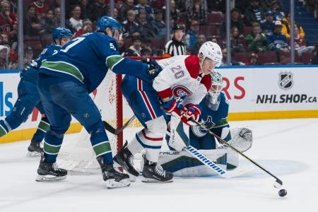 Mar 11, 2025; Vancouver, British Columbia, CAN; Vancouver Canucks goalie Kevin Lankinen (32) watches as defenseman Tyler Myers (57) battles with Montreal Canadiens forward Juraj Slafkovsk&yacute; (20) in the third period at Rogers Arena. Mandatory Credit: Bob Frid-Imagn Images