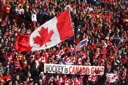 Feb 20, 2011; Calgary, AB, Canada; Canadian hockey fans wave a flag and display a banner before the Heritage Classic between the Montreal Canadiens and the Calgary Flames at McMahon Stadium. The Flames beat the Canadiens 4-0. Mandatory Credit: Tom Szczerbowski-Imagn Images