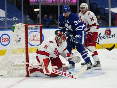 Feb 7, 2022; Toronto, Ontario, CAN; Carolina Hurricanes goaltender Frederik Andersen (31) covers up a rebound as Toronto Maple Leafs forward Auston Matthews (34) and Carolina Hurricanes defenseman Brady Skjei (76) close in during the first period at Scotiabank Arena. Mandatory Credit: John E. Sokolowski-Imagn Images