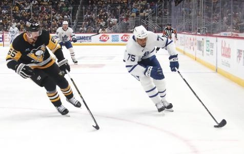 Mar 2, 2025; Pittsburgh, Pennsylvania, USA; Toronto Maple Leafs right wing Ryan Reaves (75) moves the puck as Pittsburgh Penguins defenseman Erik Karlsson (65) chases .during the third period at PPG Paints Arena. Mandatory Credit: Charles LeClaire-Imagn Images