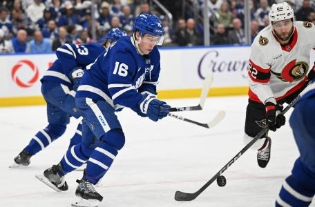 Apr 22, 2025; Toronto, Ontario, CAN; Toronto Maple Leafs forward Mitch Marner (16) reaches for the puck against Ottawa Senators forward Michael Amadio (22) in the second period in game two of the first round of the 2025 Stanley Cup Playoffs at Scotiabank Arena. Mandatory Credit: Dan Hamilton-Imagn Images