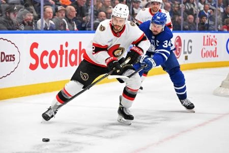 Mar 15, 2025; Toronto, Ontario, CAN; Ottawa Senators defenseman Artem Zub (2) skates the puck away from Toronto Maple Leafs forward Auston Matthews (34) in the third period at Scotiabank Arena. Mandatory Credit: Dan Hamilton-Imagn Images