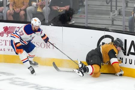 May 8, 2025; Las Vegas, Nevada, USA; Vegas Golden Knights defenseman Brayden McNabb (3) impacts the boards after being tripped by Edmonton Oilers left wing Viktor Arvidsson (33) during an overtime period of game two of the second round of the 2025 Stanley Cup Playoffs at T-Mobile Arena. Mandatory Credit: Stephen R. Sylvanie-Imagn Images