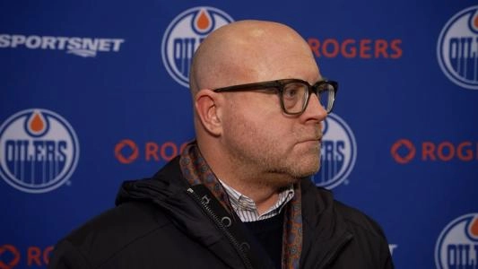 Edmonton Oilers GM Stan Bowman looks to the side during an interview