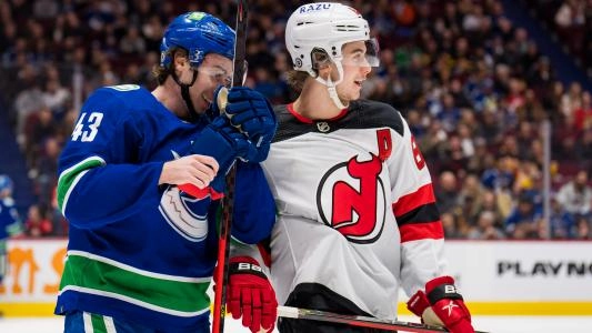 Vancouver Canucks' Quinn Hughes next to his brother Jack Hughes of the New Jersey Devils
