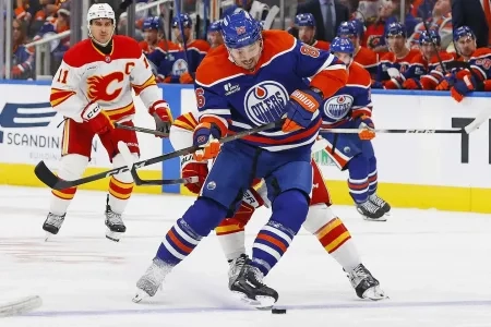 Oilers' David Tomasek fights for puck in game versus the Calgary Flames