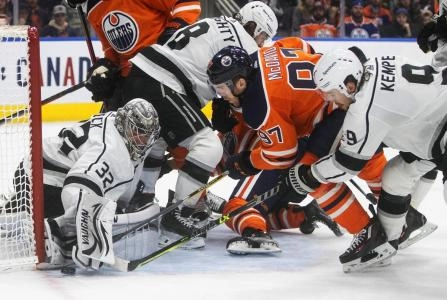 Edmonton Oilers and Los Angeles Kings players battle for the puck