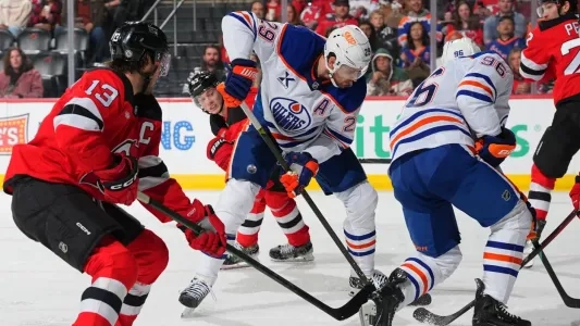 Leon Draisaitl and Nico Hischier battling for a puck in front of the net.