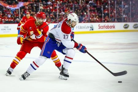 8 mars 2025 ; Calgary, Alberta, Canada ; L'ailier droit des Canadiens de Montr&eacute;al Josh Anderson (17) contr&ocirc;le la rondelle face au centre des Flames de Calgary Nazem Kadri (91) lors de la troisi&egrave;me p&eacute;riode au Scotiabank Saddledome.
