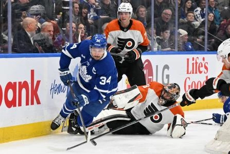 Mar 25, 2025; Toronto, Ontario, CAN; Toronto Maple Leafs forward Auston Matthews (34) plays the puck away from Philadelphia Flyers goalie Samuel Ersson (33) and forward Tyson Foerster (71) in the third period at Scotiabank Arena. Mandatory Credit: Dan Hamilton-Imagn Images
