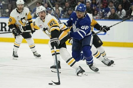 Dec 16, 2023; Toronto, Ontario, CAN; Pittsburgh Penguins defenseman Erik Karlsson (65) and Toronto Maple Leafs forward William Nylander (88) battle for a puck during the first period at Scotiabank Arena