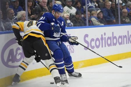 Nov 3, 2025; Toronto, Ontario, CAN; Toronto Maple Leafs forward John Tavares (91) battles with Pittsburgh Penguins defenseman Harrison Brunicke (45) during the first period at Scotiabank Arena. Mandatory Credit: John E. Sokolowski-Imagn Images