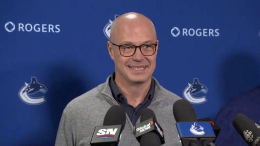 Vancouver Canucks GM Patrik Allvin smiles with reporters
