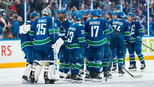 Vancouver Canucks players on the ice celebrate a win