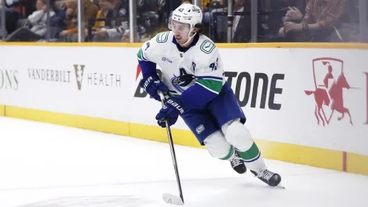 Vancouver Canucks defenseman Quinn Hughes playing in a road game in the NHL.
