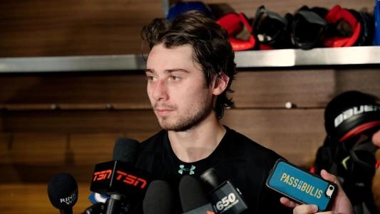 Vancouver Canucks' Quinn Hughes speaks to reporters in the locker room