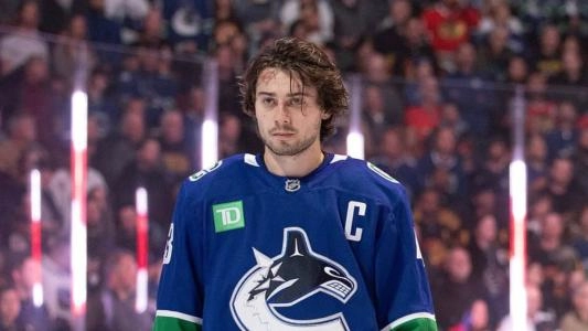 Vanxcouver Canucks' Quinn Hughes stands during the anthems