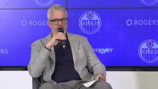 Edmonton Oilers CEO Jeff Jackson speaks to the media holding a microphone