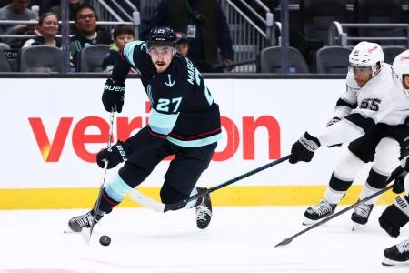 Dec 10, 2025; Seattle, Washington, USA; Seattle Kraken left wing Mason Marchment (27) moves the puck past Los Angeles Kings right wing Quinton Byfield (55) in the third period at Climate Pledge Arena.