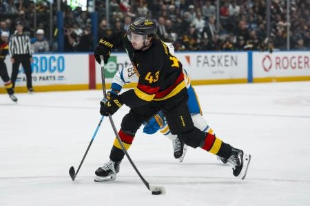 Dec 11, 2025; Vancouver, British Columbia, CAN; Vancouver Canucks defenseman Quinn Hughes (43) shoots against the Buffalo Sabres in the first period at Rogers Arena.