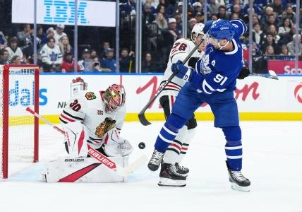 Dec 16, 2025; Toronto, Ontario, CAN; Toronto Maple Leafs center John Tavares (91) battles for the puck with Chicago Blackhawks left wing Nick Lardis (76) during the first period at Scotiabank Arena.