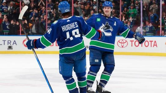 Vancouver Canucks' Quinn Hughes and JT Miller celebrate a goal