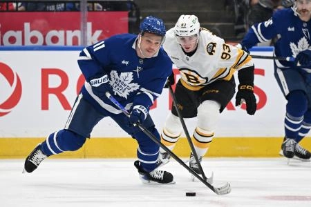 Nov 8, 2025; Toronto, Ontario, CAN; Toronto Maple Leafs forward Max Domi (11) moves the puck past Boston Bruins forward Fraser Minten (93) in the third period at Scotiabank Arena