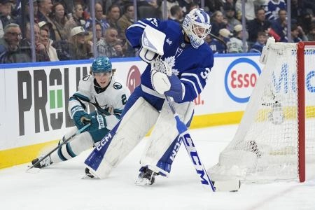 Dec 11, 2025; Toronto, Ontario, CAN; Toronto Maple Leafs goaltender Dennis Hildeby (35) carries the puck as San Jose Sharks forward Will Smith (2) pursues during the second period at Scotiabank Arena.