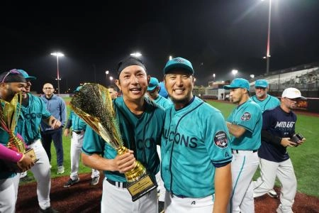 Mid East Falcons infielder Munenori Kawasaki holds up his MVP trophy for photographers.