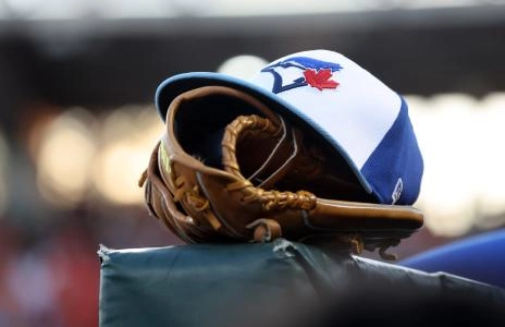 Mar 18, 2025; Sarasota, Florida, USA; A detail view of a Toronto Blue Jays hat and glove against the Baltimore Orioles at Ed Smith Stadium. Mandatory Credit: Kim Klement Neitzel-Imagn Images