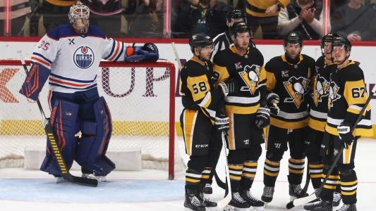 Pittsburgh Penguins players look up at the scoreboard in front of Edmonton Oilers' Tristan Jarry