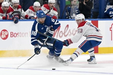 6 d&eacute;cembre 2025 ; Toronto, Ontario, CAN ; L'attaquant des Maple Leafs de Toronto William Nylander (88) passe la rondelle devant l'attaquant des Canadiens de Montr&eacute;al Cole Caufield (13) au cours de la deuxi&egrave;me p&eacute;riode au Scotiabank Arena.