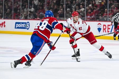 25 f&eacute;vrier 2025; Montr&eacute;al, Qu&eacute;bec, Canada; Jesperi Kotkaniemi (82), centre des Hurricanes de la Caroline, joue la rondelle contre Lane Hutson (48), d&eacute;fenseur des Canadiens de Montr&eacute;al, en deuxi&egrave;me p&eacute;riode au Centre Bell.