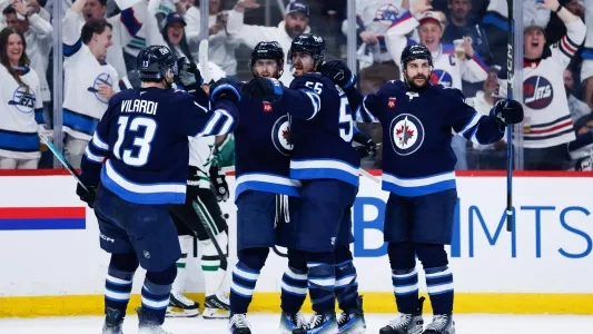 Winnipeg Jets players celebrate a goal on the ice