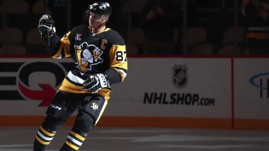 Pittsburgh Penguins' Sidney Crosby skates out with the lights dimmed