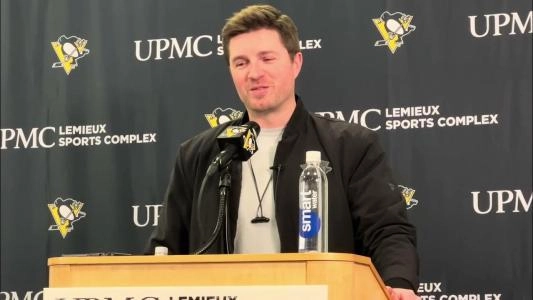 Pittsburgh Penguins GM Kyle Dubas with a grin on his face at a presser