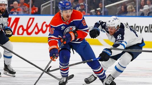 Edmonton Oilers' David Tomasek skates with the puck vs. the Winnipeg Jets
